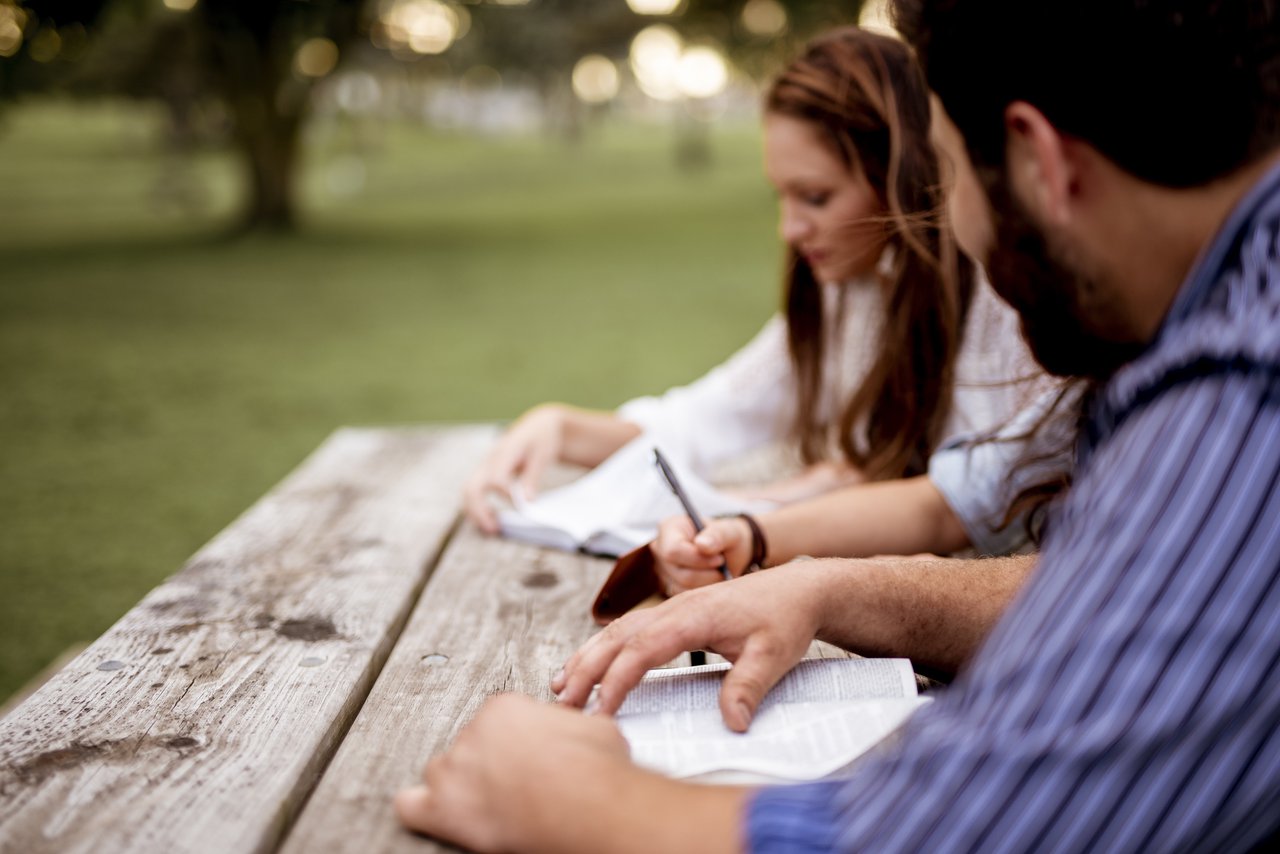 closeup-shot-people-sitting-park-reading-bible (1).jpg