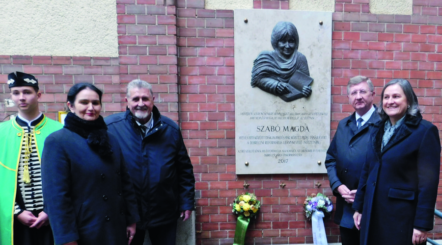A Dóczy falán levő Szabó Magda-dombormű koszorúzása. A tógás diák mellett Perla Erzsébet  tanár, Tasi Géza előadóművész, Fekete Károly püspök és Czapp Katalin igazgató